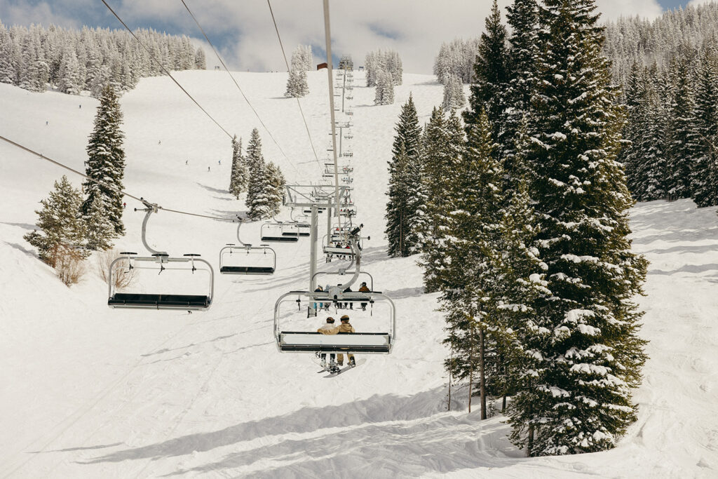 Couple rides the ski lift in Vail during their engagement session