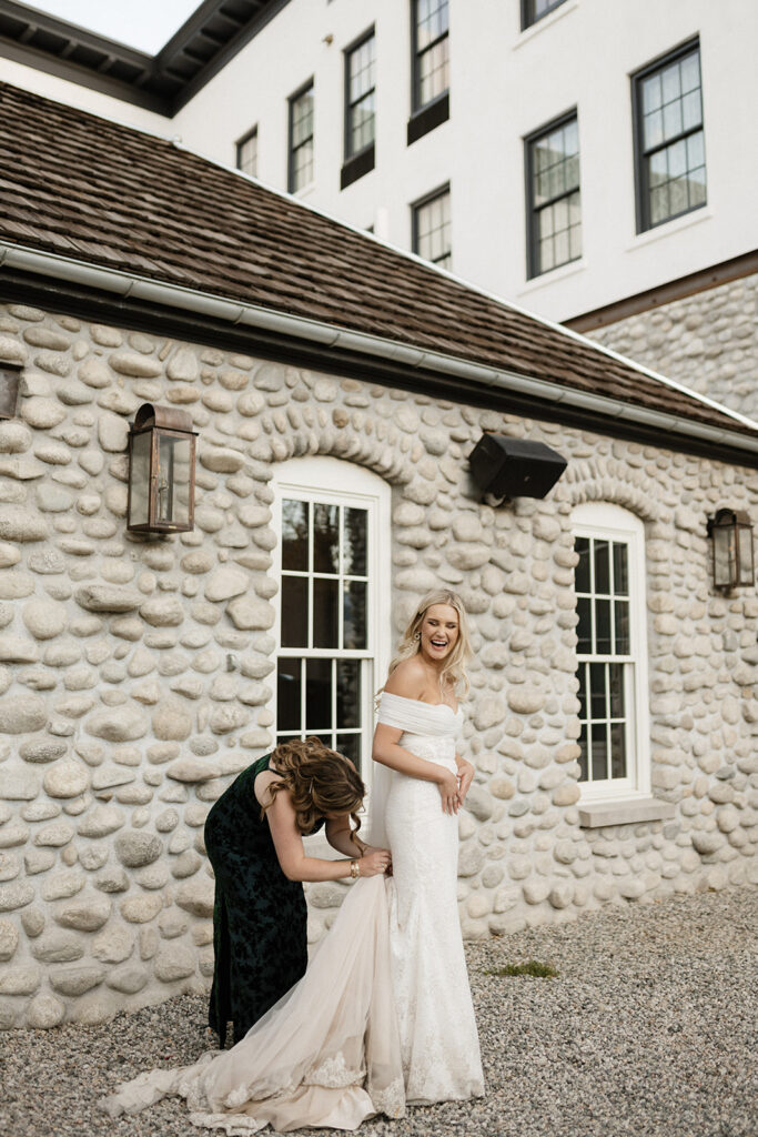 Bride gets her dress bustled in front of Surf Hotel and Chateau
