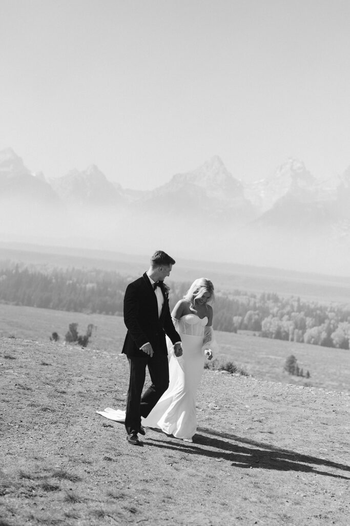 Tetons stand tall in the background of bride and groom in Wyoming