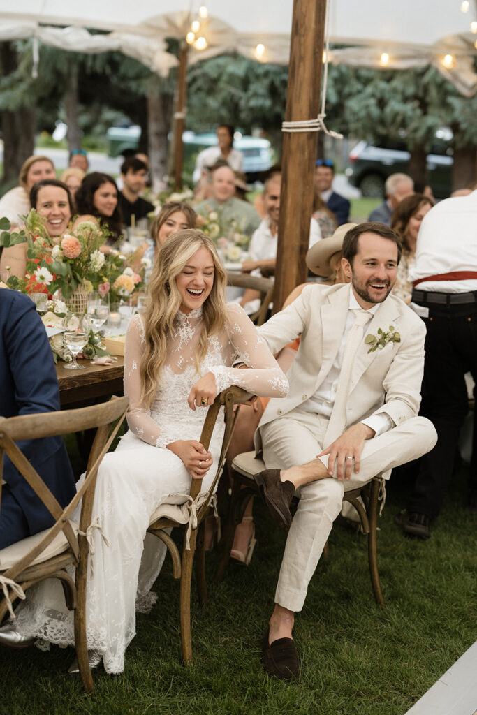 bride and groom laugh during their Coastal cowgirl inspired wedding reception