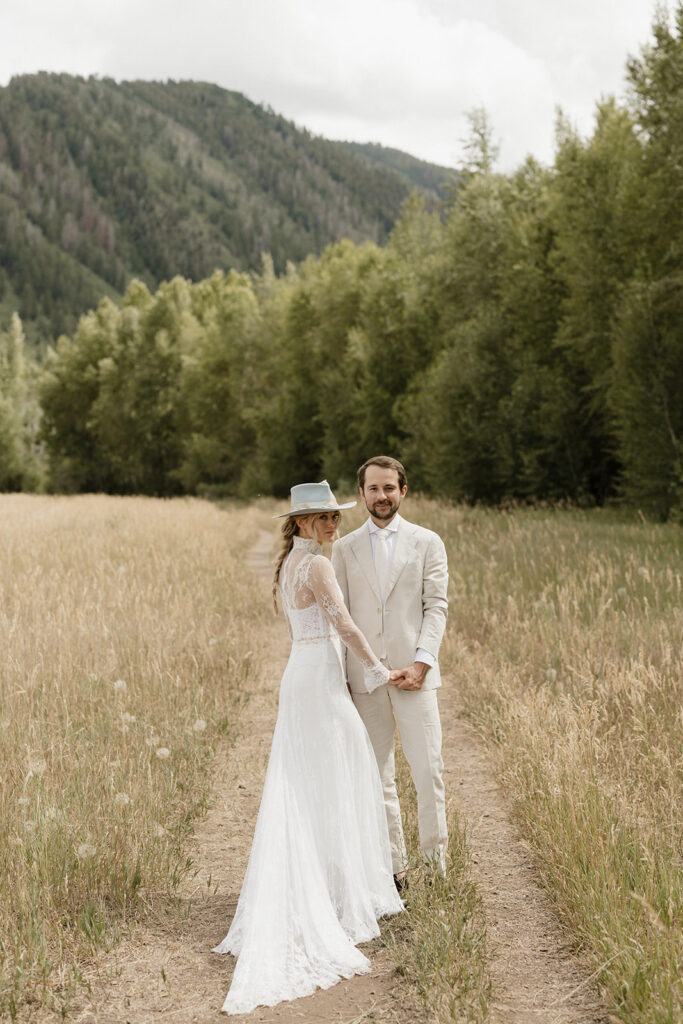 Coastal cowgirl inspired bride and groom photos in a field in Aspen