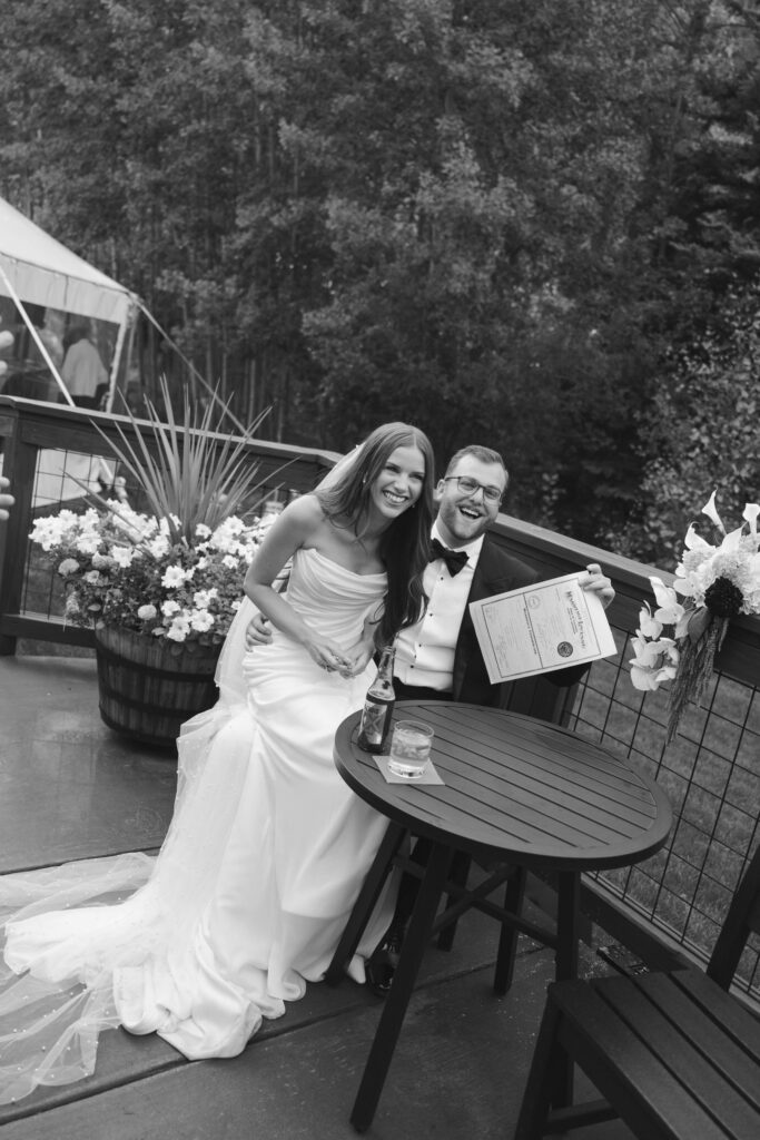Bride and groom proudly show their signed marriage license