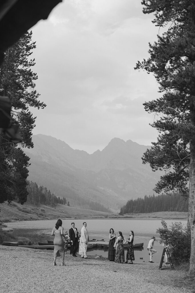 Wedding guest gather near the alpine lake at Piney River Ranch