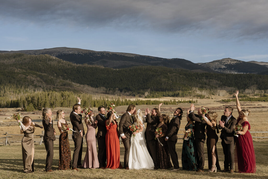 Fall wedding party attire at Devil's Thumb Ranch with mountains in the backdrop