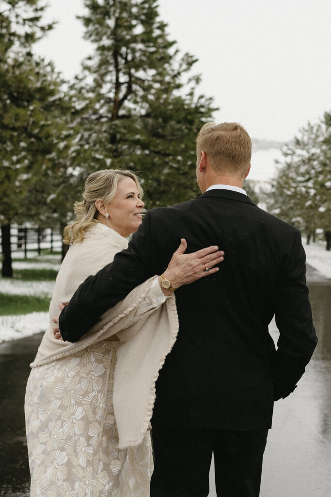 Groom sharing a warm moment with mom during winter wedding day