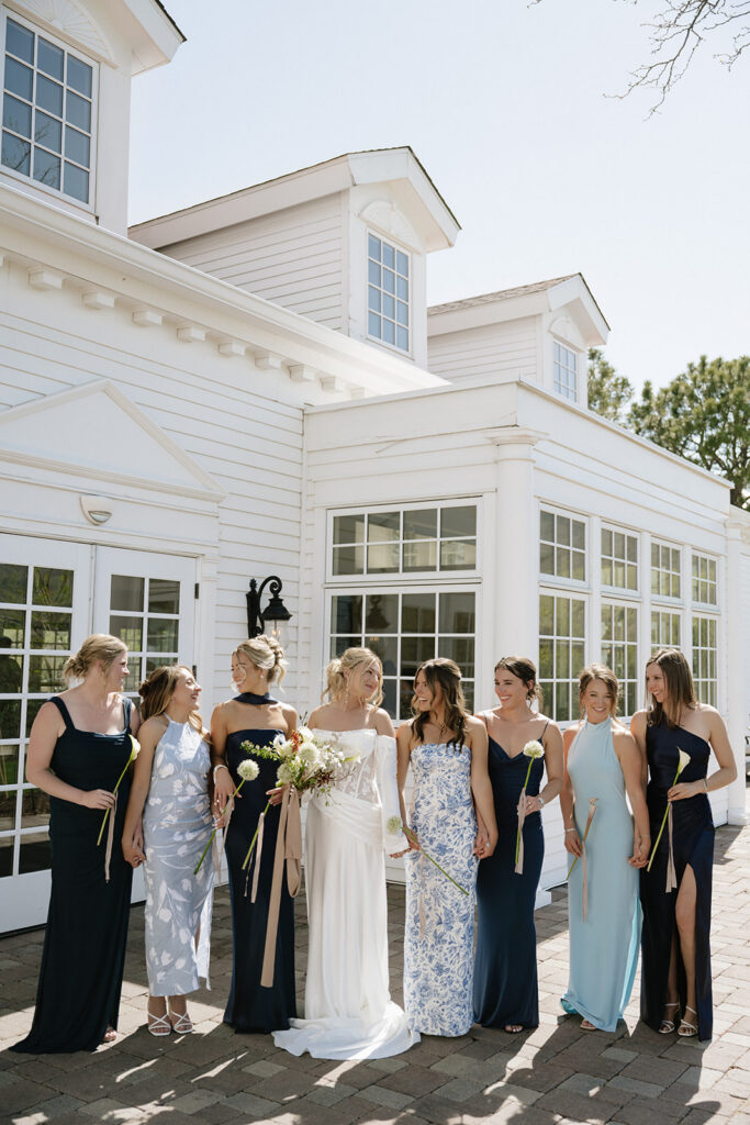 Bride and bridesmaids stand in front of The Manor House
