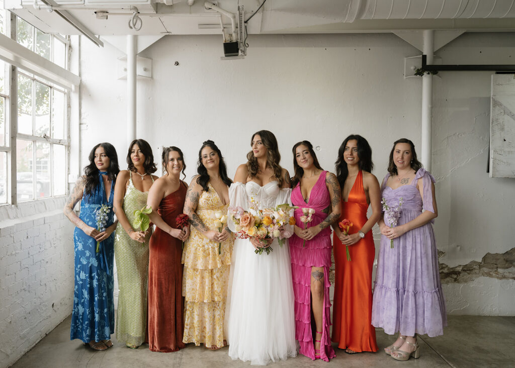 Bride and bridesmaids wearing colorful mismatched dresses