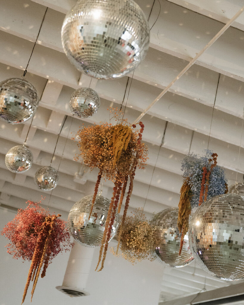 Hanging floral installations and disco balls at wedding reception