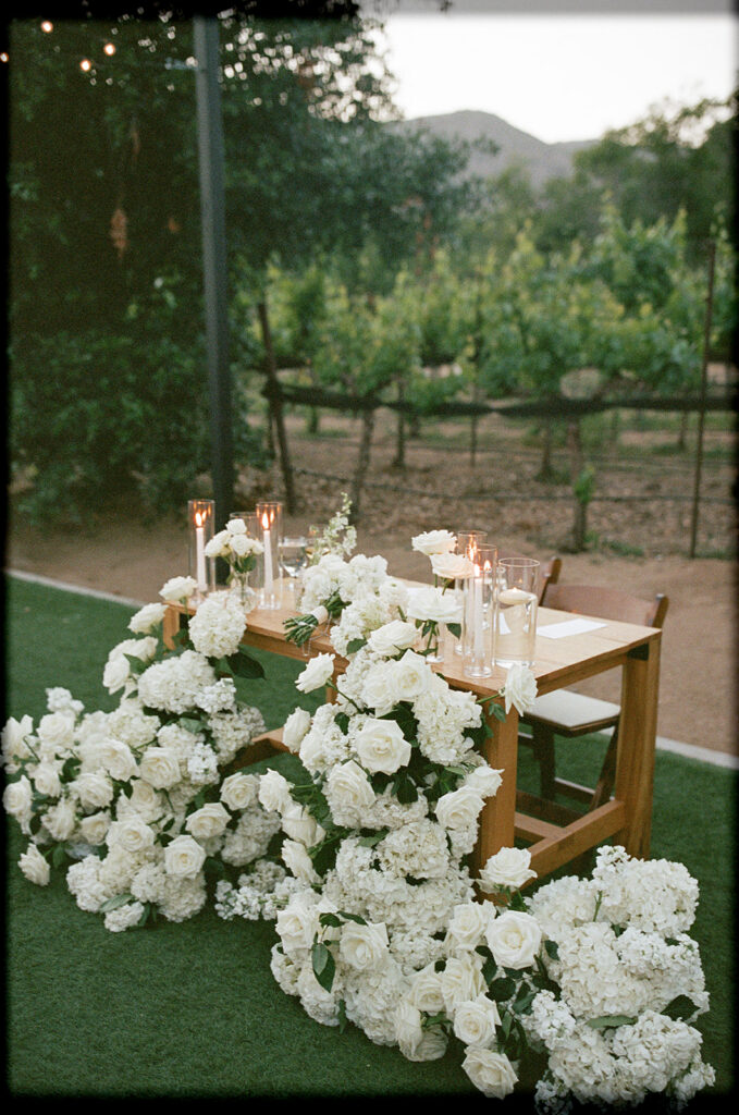 Bride and groom table with flowing white florals captured on 35mm film