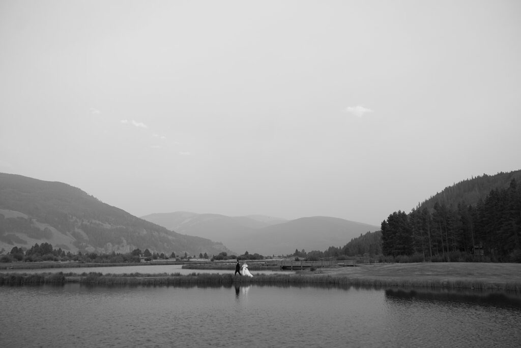 Bride and groom walk out on an island at Camp Hale