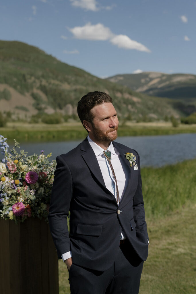 Groom watches his bride walk down the aisle at Camp Hale