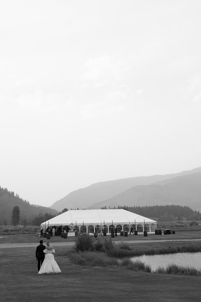 Bride and groom walk to their Camp Hale wedding reception tent