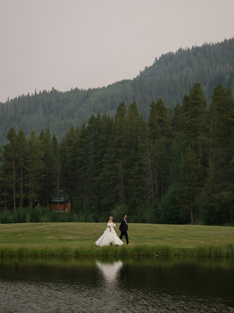 Bride and groom walk around the river at Camp Hale