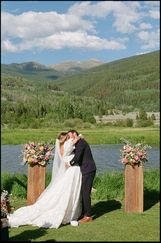 Bride and groom kiss at their Camp Hale wedding ceremony